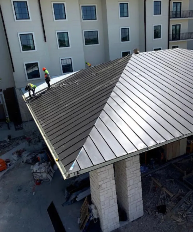 Crew installing standing seam metal roof panels on a commercial project in Culver City